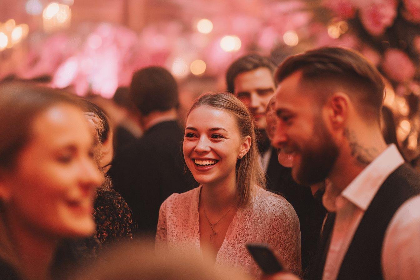 Groupe d'amis souriant dans une ambiance festive rose