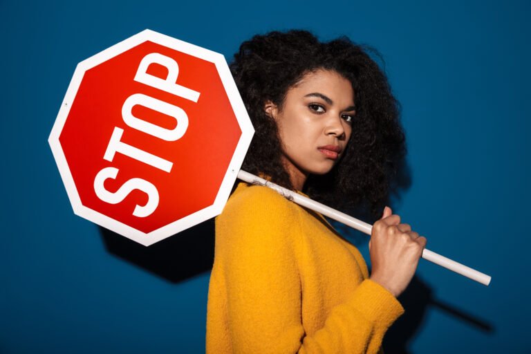 jeune femme typé metisse qui porte un panneau stop sur l'epaule
