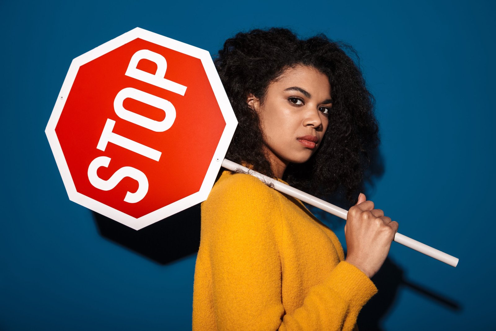 jeune femme typé metisse qui porte un panneau stop sur l'epaule