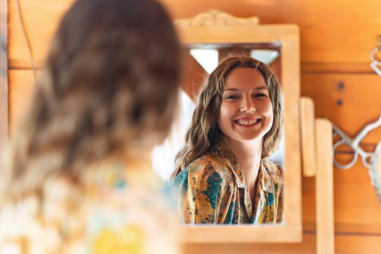 femme qui se regarde en souriant dans un miroir