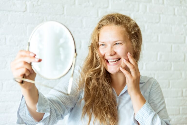 femme rayonnante qui se regarde dans un miroir glow up