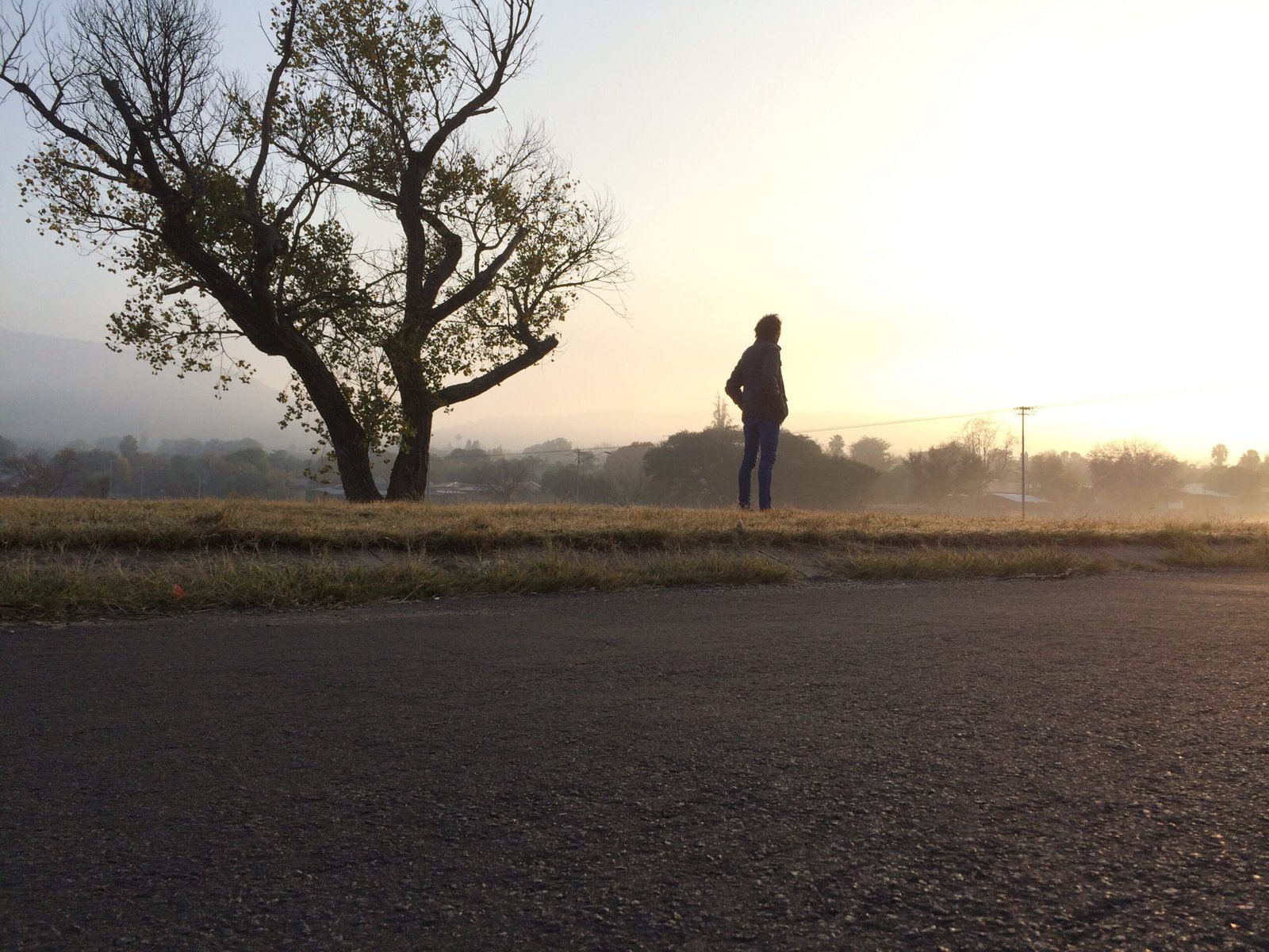 homme debout dans la campagne au lever du soleil